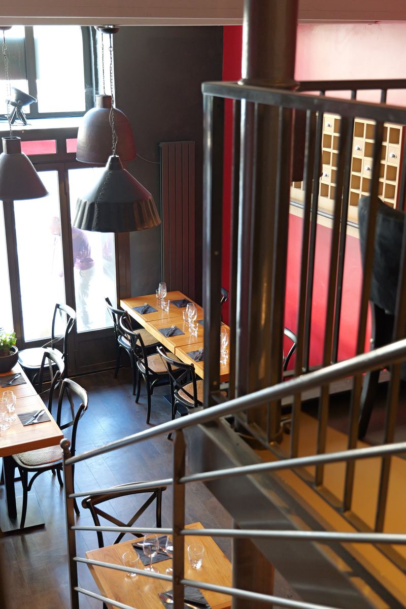 La salle vue de la mezzanine, mur rouge et suspensions